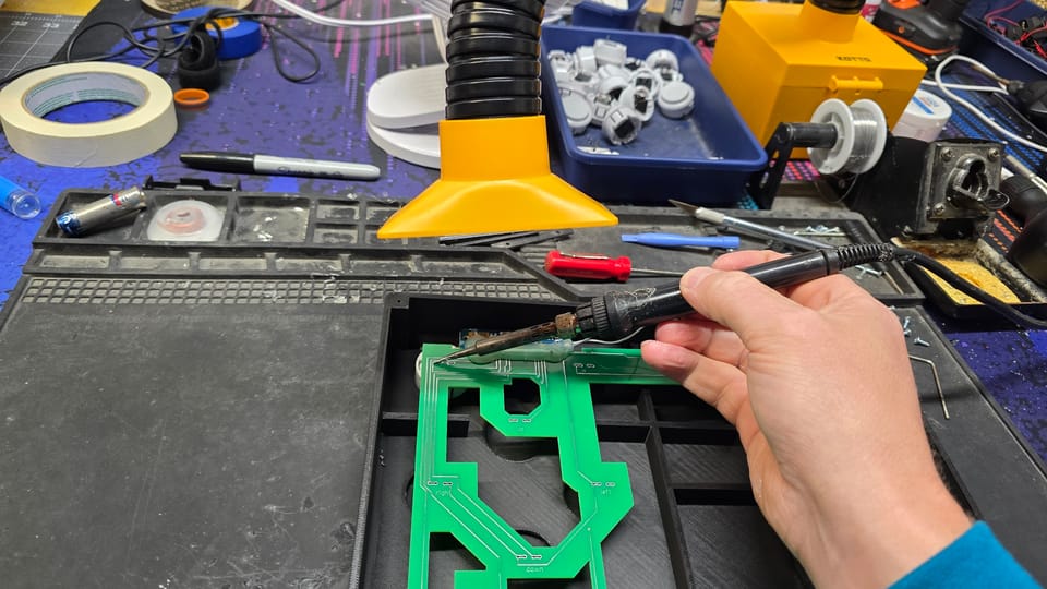 Soldering the wireless board to the control box circuit board under a fume extractor